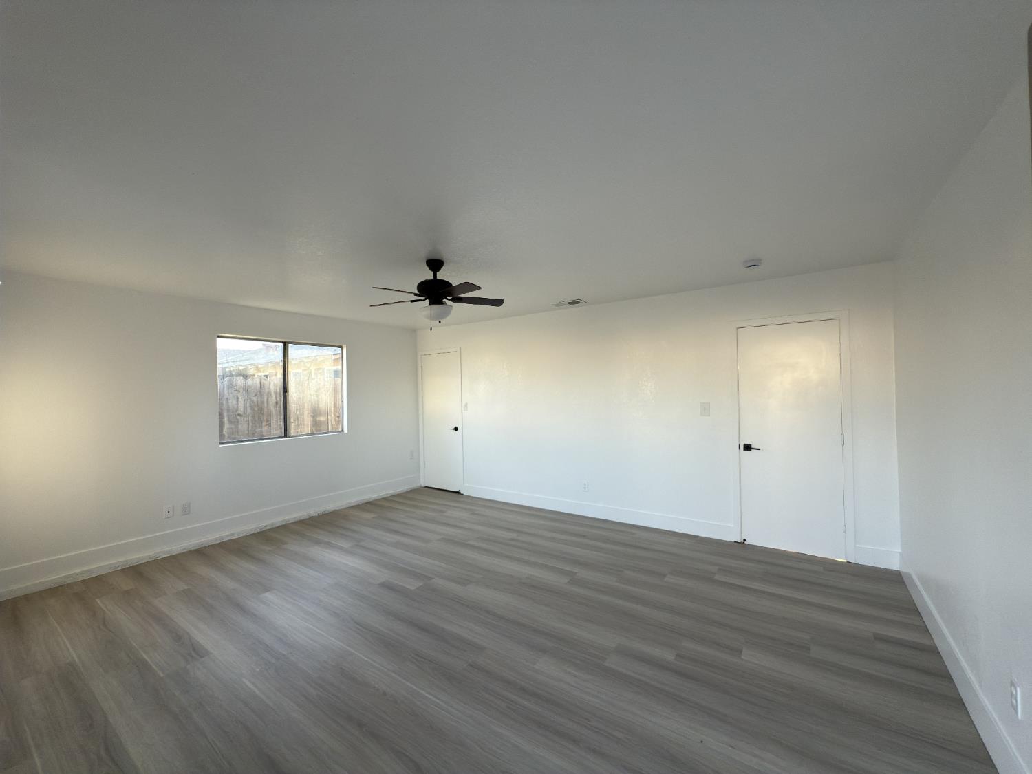 21303 South Wyatt Avenue Riverdale, CA 93656 - Photo 13 of 14 an empty room with wooden floor and windows
