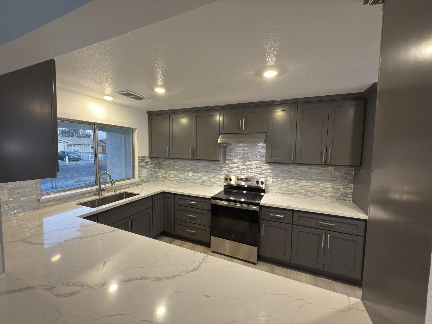 21303 South Wyatt Avenue Riverdale, CA 93656 - Photo 3 of 14 a kitchen with stainless steel appliances granite countertop a sink stove and cabinets