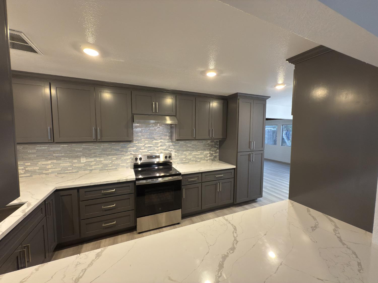 21303 South Wyatt Avenue Riverdale, CA 93656 - Photo 4 of 14 a large kitchen with granite countertop a stove and a sink
