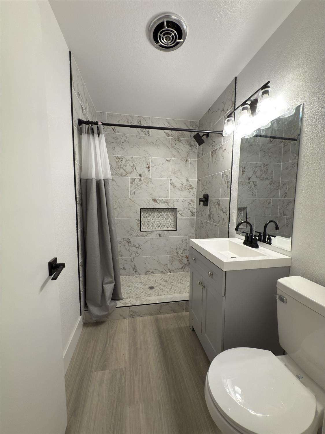 21303 South Wyatt Avenue Riverdale, CA 93656 - Photo 9 of 14 a bathroom with a sink a toilet a mirror and shower