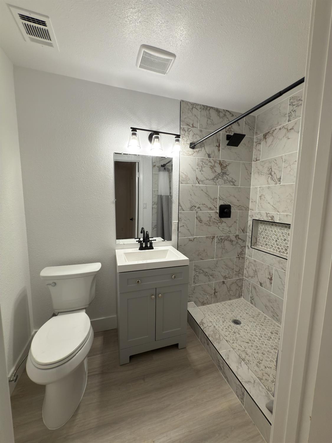 21303 South Wyatt Avenue Riverdale, CA 93656 - Photo 10 of 14 a bathroom with a granite countertop sink toilet and shower