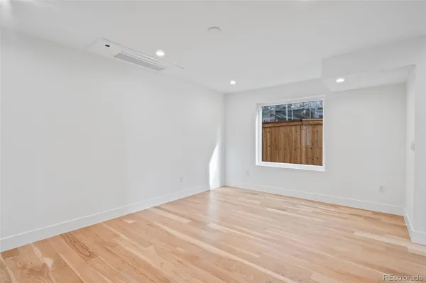 a view of empty room with wooden floor