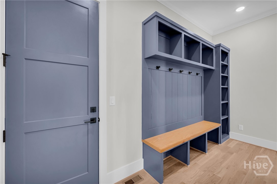 2476 St Martin Way Monroe, GA 30656 - Photo 29 of 75 Mudroom featuring custom blue built-in cabinetry with bench seating, open shelving, and coat hooks