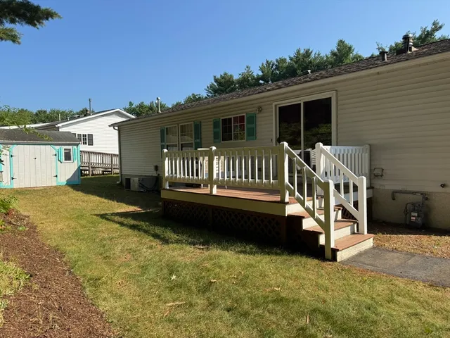 a view of a house with a yard chairs and floor to ceiling window