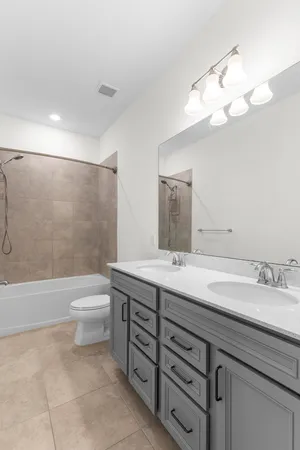 a bathroom with a double vanity sink mirror and toilet