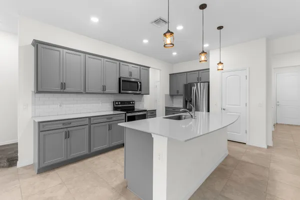 a kitchen with kitchen island a sink appliances and cabinets