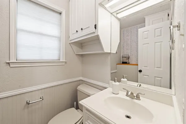 a bathroom with a sink mirror and toilet