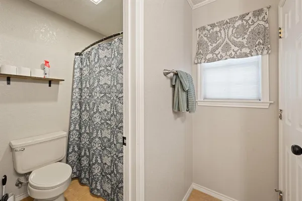 a bathroom with a toilet and a shower curtain