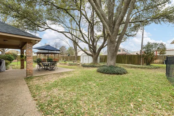 a view of patio with table and chairs under an umbrella