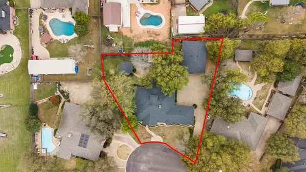 an aerial view of a residential houses with yard