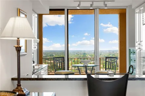 a view of a living room with a table & chairs
