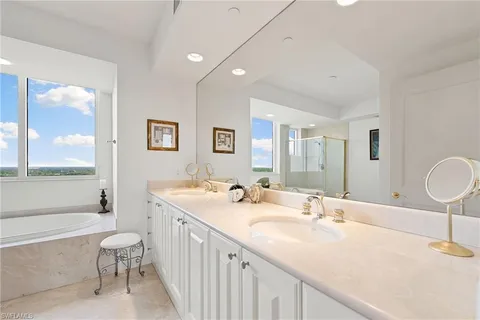 a bathroom with a double vanity sink toilet mirror and bathtub