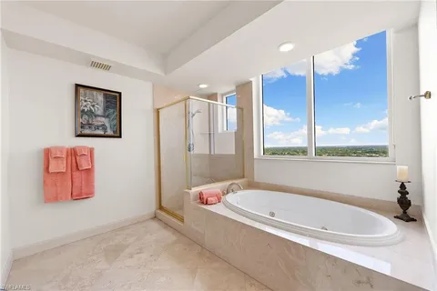 a bathroom with a tub a sink and a large mirror