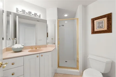 a bathroom with a granite countertop sink toilet and shower