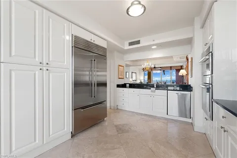a kitchen with stainless steel appliances a refrigerator and white cabinets