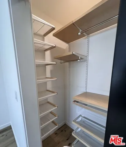 a view of walk in closet with empty racks
