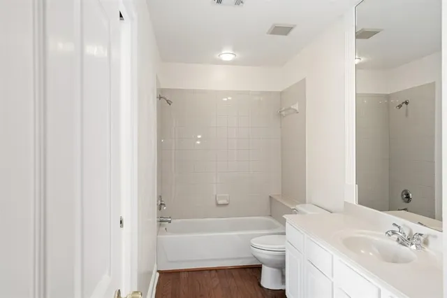 a bathroom with a bathtub shower sink vanity mirror and toilet