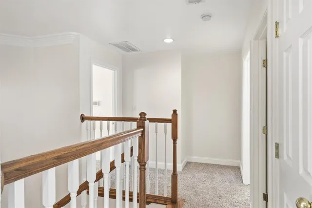 a view of staircase with railing and white walls