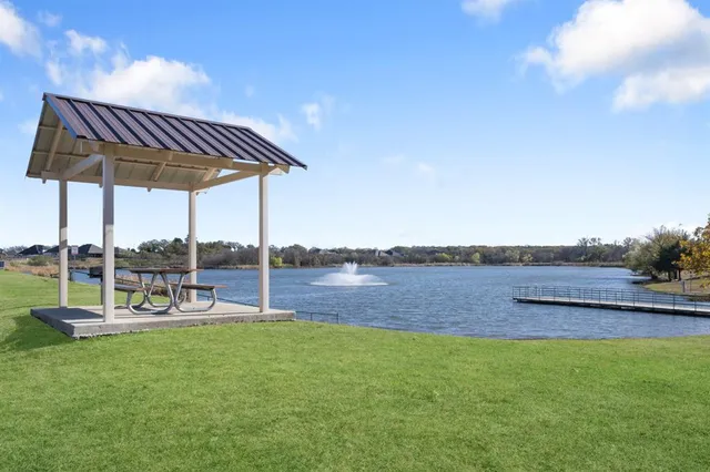 a view of a swimming pool with lawn chairs under an umbrella