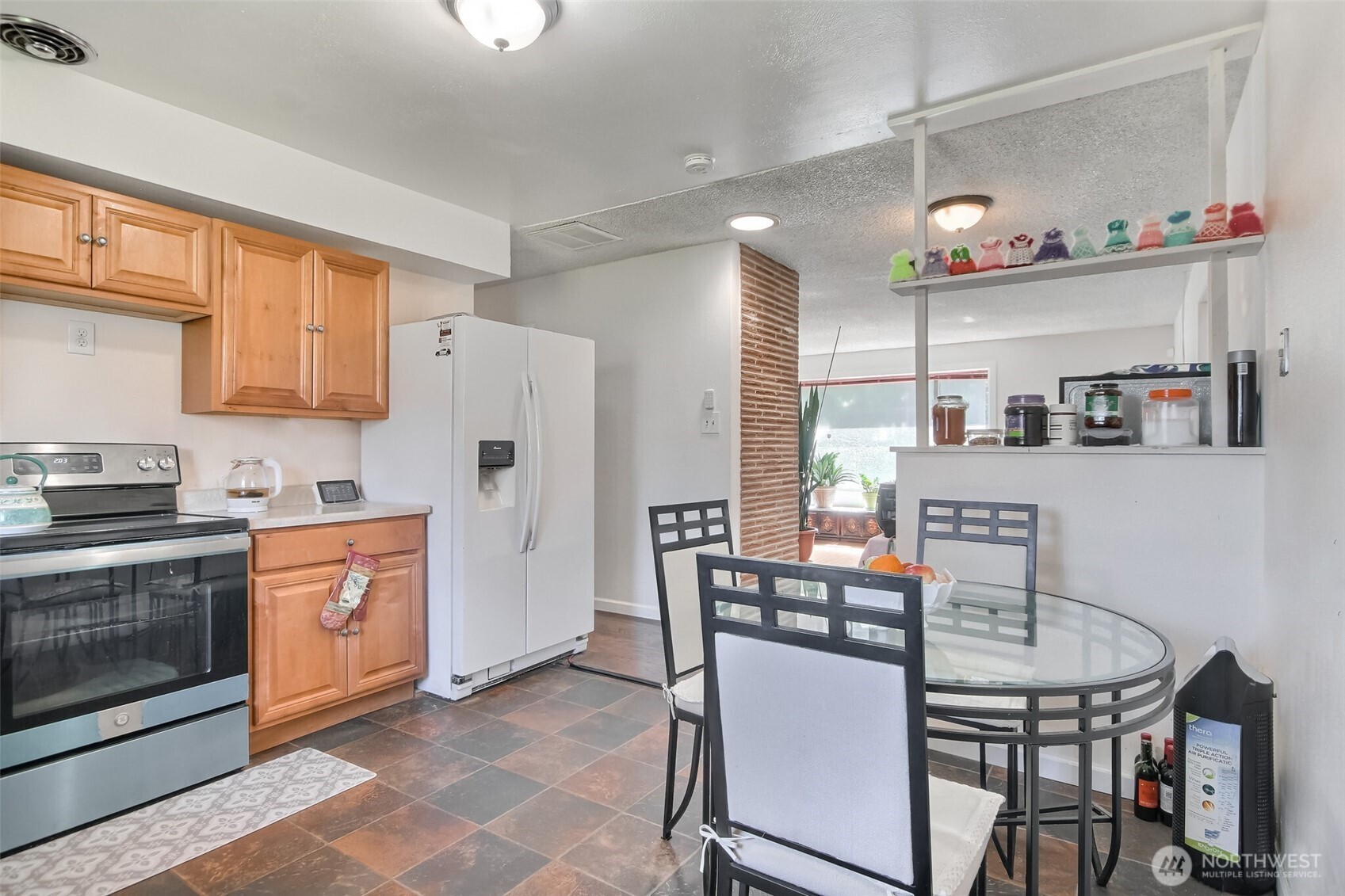 810 Southwest 356th Street Federal Way, WA 98023 - Photo 14 of 40 a kitchen with stainless steel appliances granite countertop a stove a refrigerator a dining table and chairs with wooden floor