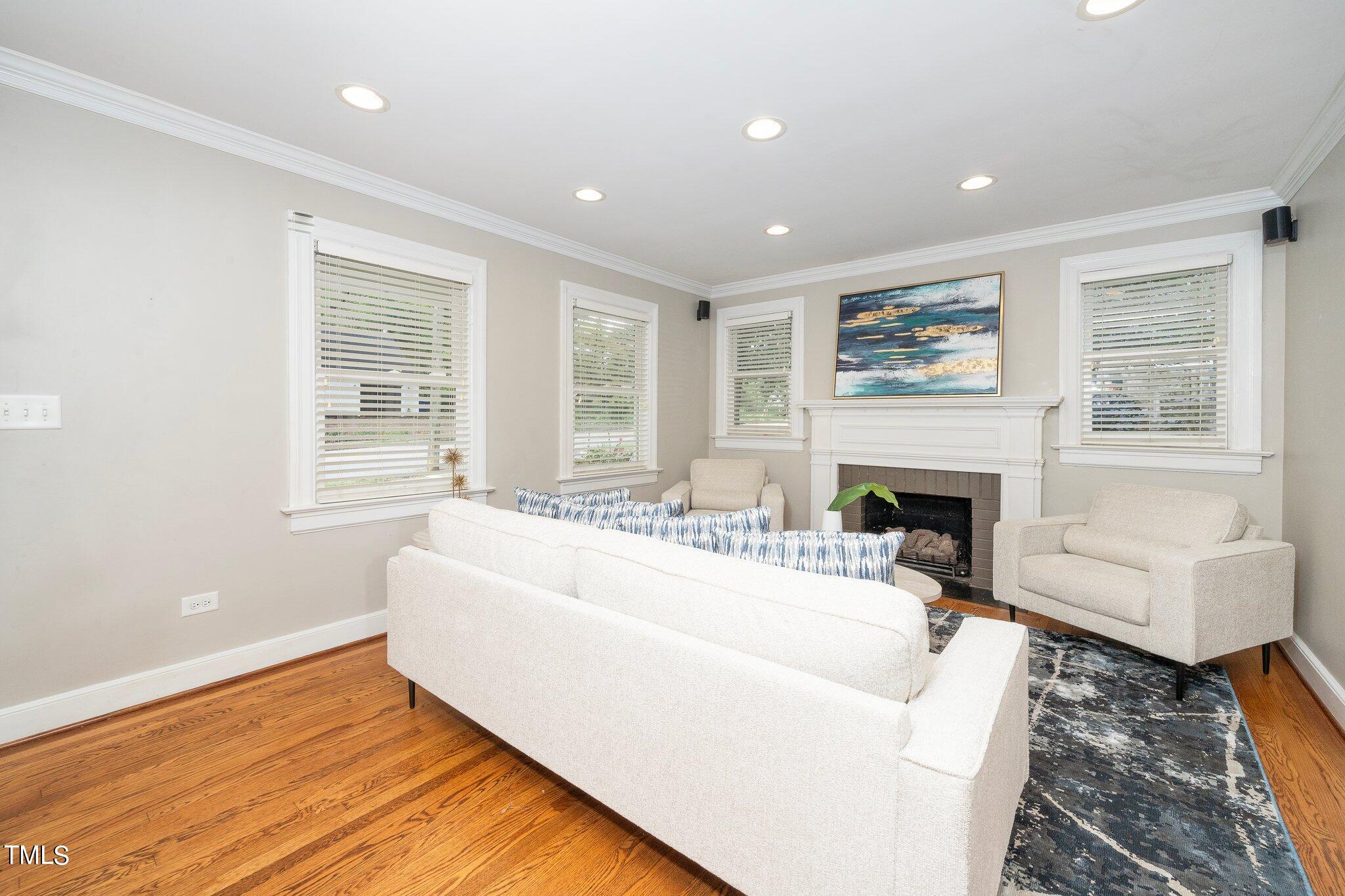 406 Brooks Avenue Raleigh, NC 27607 - Photo 7 of 33 a living room with furniture a fireplace and a large window