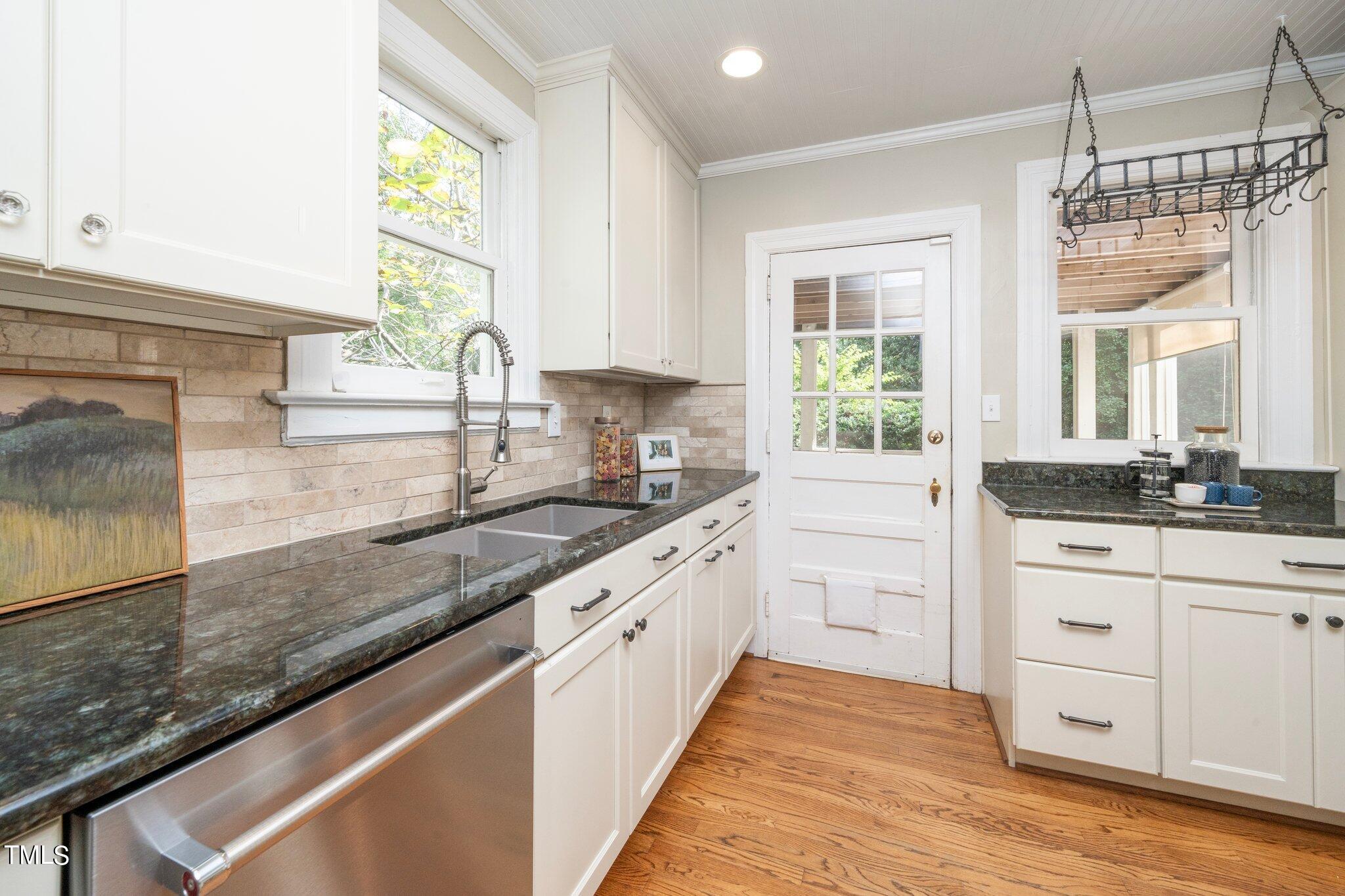 406 Brooks Avenue Raleigh, NC 27607 - Photo 10 of 33 a large kitchen with granite countertop a sink window and cabinets