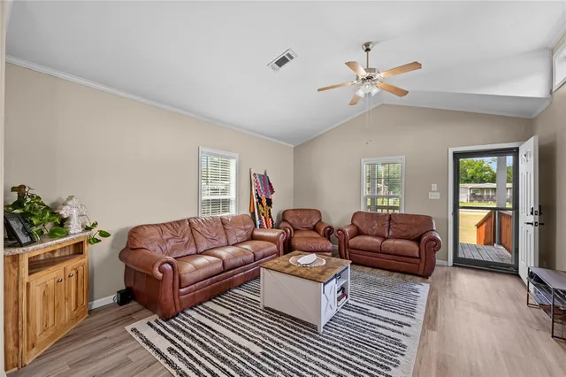 a living room with furniture a ceiling fan and a rug