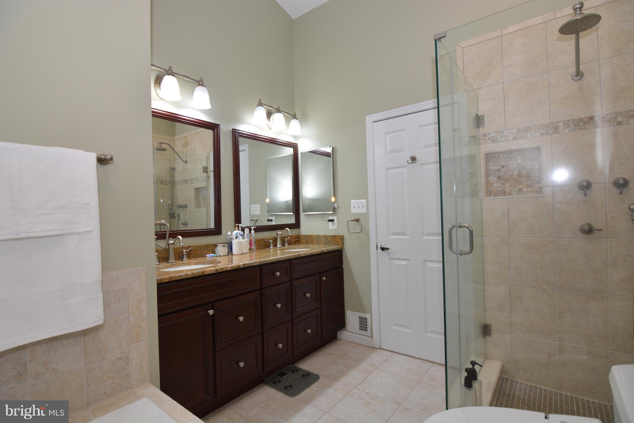 7211 Squirrel Run Court Springfield, VA 22152 - Photo 20 of 30 a bathroom with a double vanity sink mirror and shower