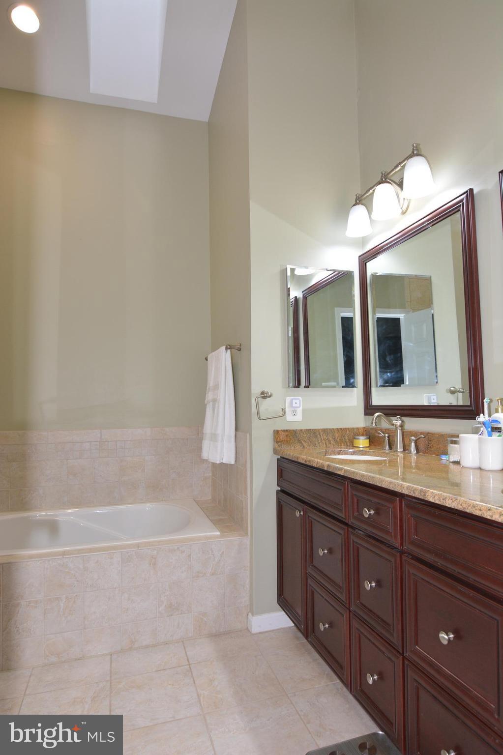 7211 Squirrel Run Court Springfield, VA 22152 - Photo 21 of 30 a bathroom with a granite countertop sink mirror and bathtub