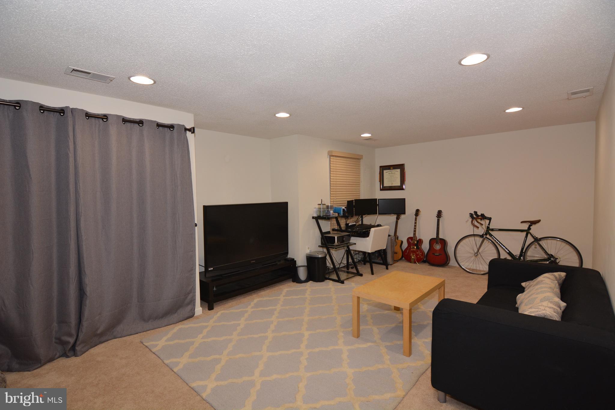 7211 Squirrel Run Court Springfield, VA 22152 - Photo 25 of 30 a living room with furniture a flat screen tv and gym equipment