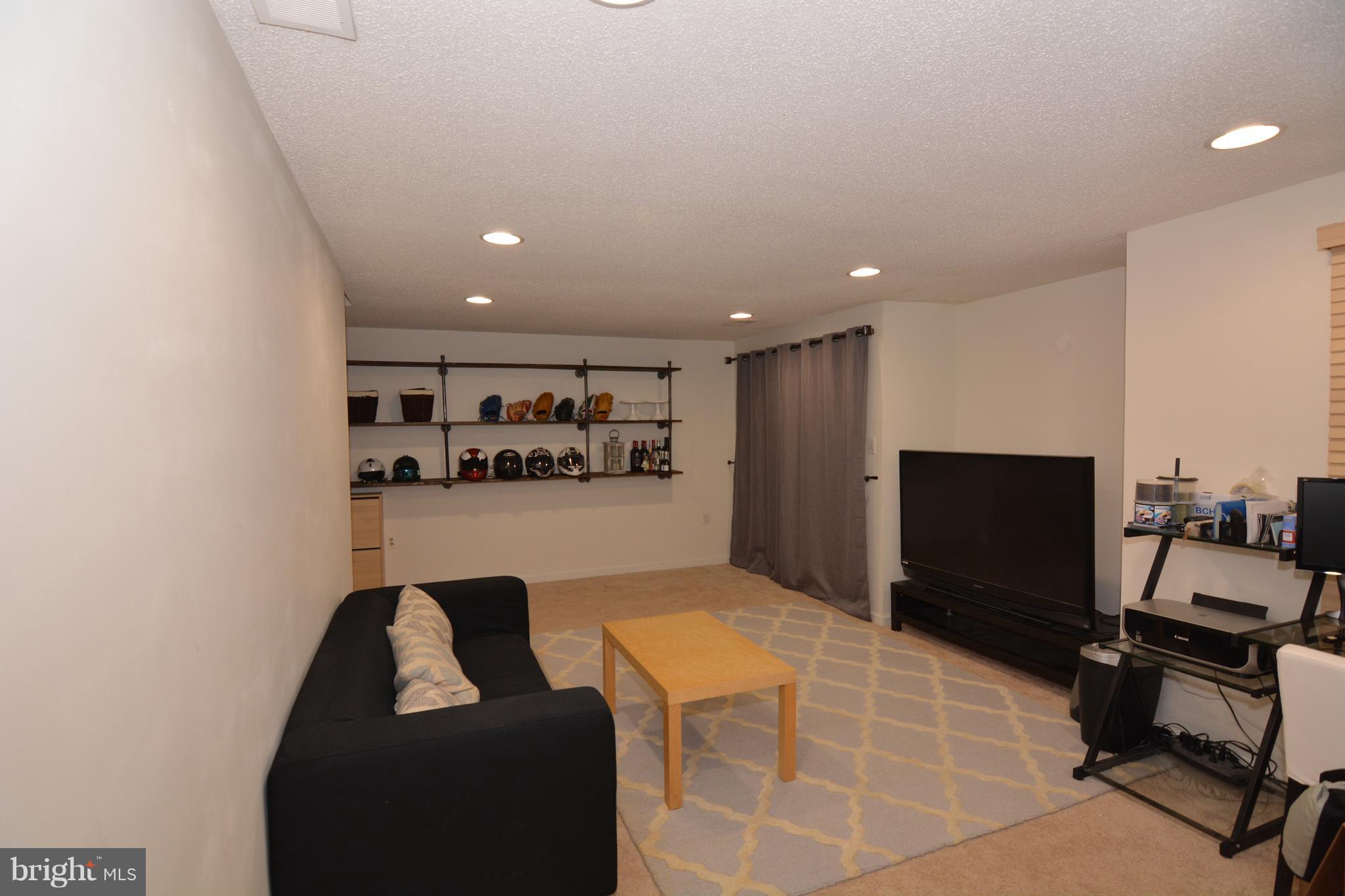 7211 Squirrel Run Court Springfield, VA 22152 - Photo 26 of 30 a projector room with a couch and a flat screen tv