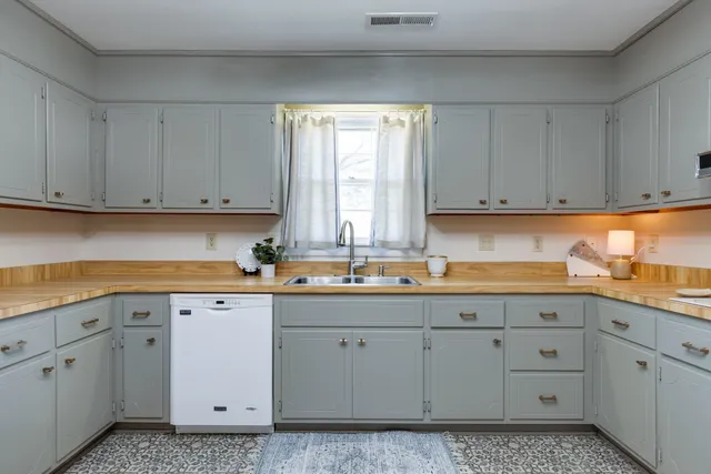 a kitchen with a sink window and cabinets