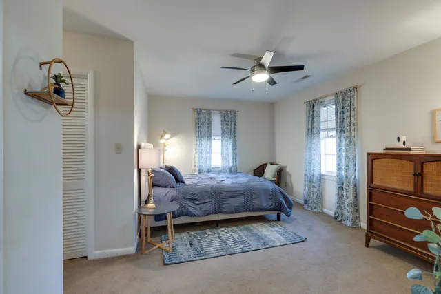 a bed room with a bed and a ceiling fan