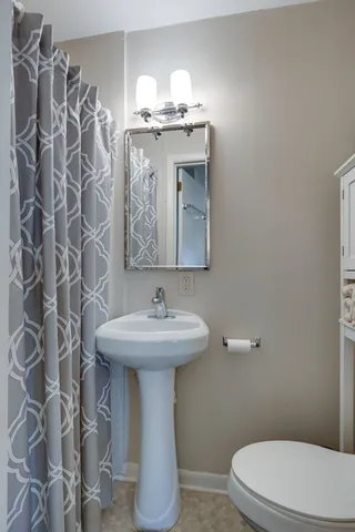 a bathroom with a toilet sink and mirror