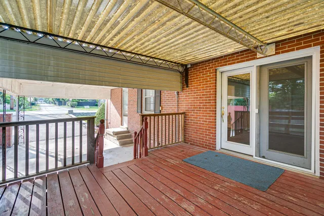 a porch with wooden floor in front of house