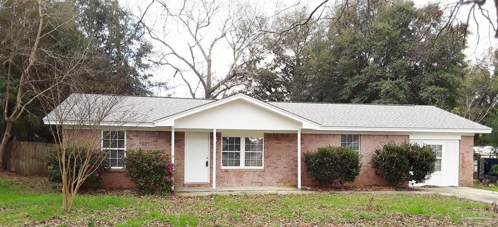 a view of a house with a yard and potted plants