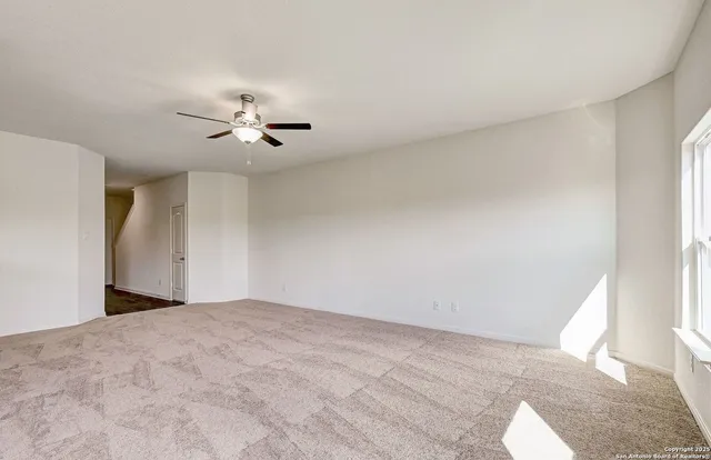a view of a room with a ceiling fan and a window