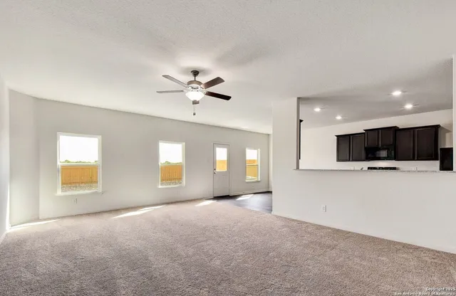 a view of a livingroom with a ceiling fan and window