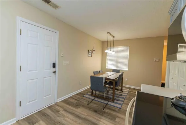 a dining room with wooden floor and furniture