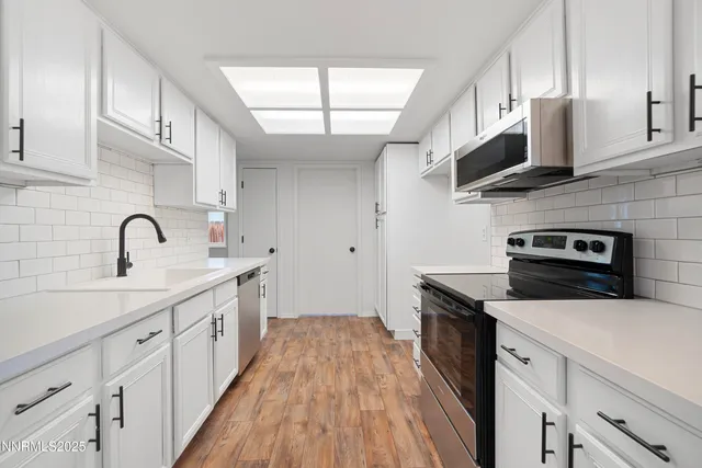 a kitchen with stainless steel appliances a sink dishwasher stove microwave and cabinets