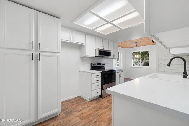 a kitchen with granite countertop a refrigerator stove top oven and sink