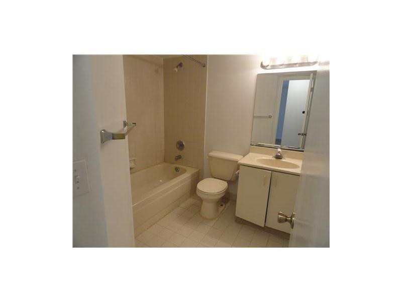9001 Wiles Road, Unit 1033 Coral Springs, FL 33067 - Photo 5 of 11 a bathroom with a toilet a sink and mirror