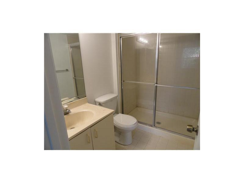 9001 Wiles Road, Unit 1033 Coral Springs, FL 33067 - Photo 7 of 11 a bathroom with a toilet a sink and shower