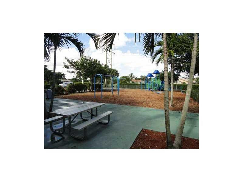 9001 Wiles Road, Unit 1033 Coral Springs, FL 33067 - Photo 10 of 11 a backyard of a house with table and chairs