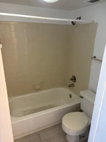 a white bath tub sitting next to a toilet
