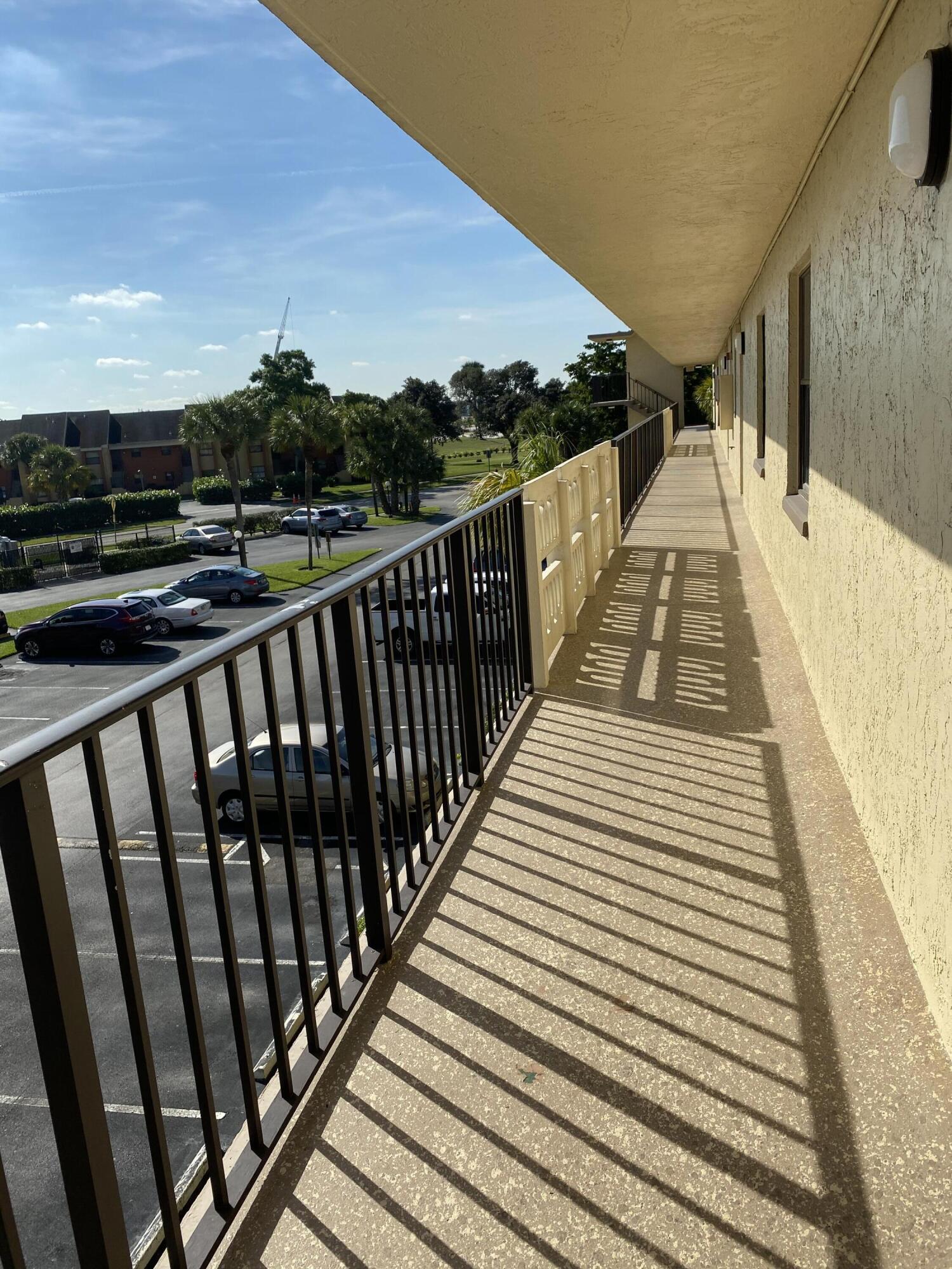 9355 Southwest 8th Street, Unit 305 Boca Raton, FL 33428 - Photo 12 of 13 a view of balcony with wooden floor and fence