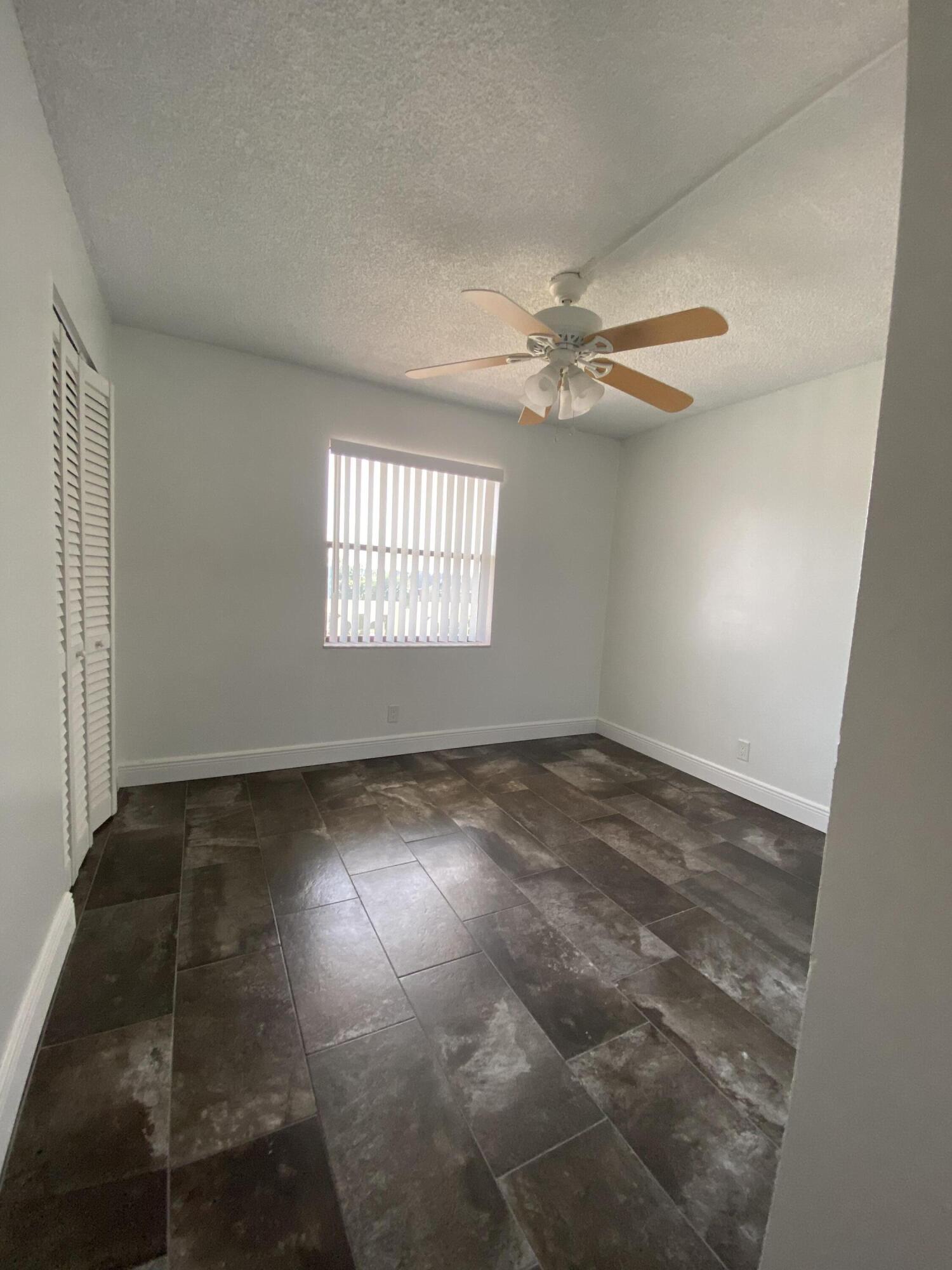 9355 Southwest 8th Street, Unit 305 Boca Raton, FL 33428 - Photo 5 of 13 an empty room with windows and fan