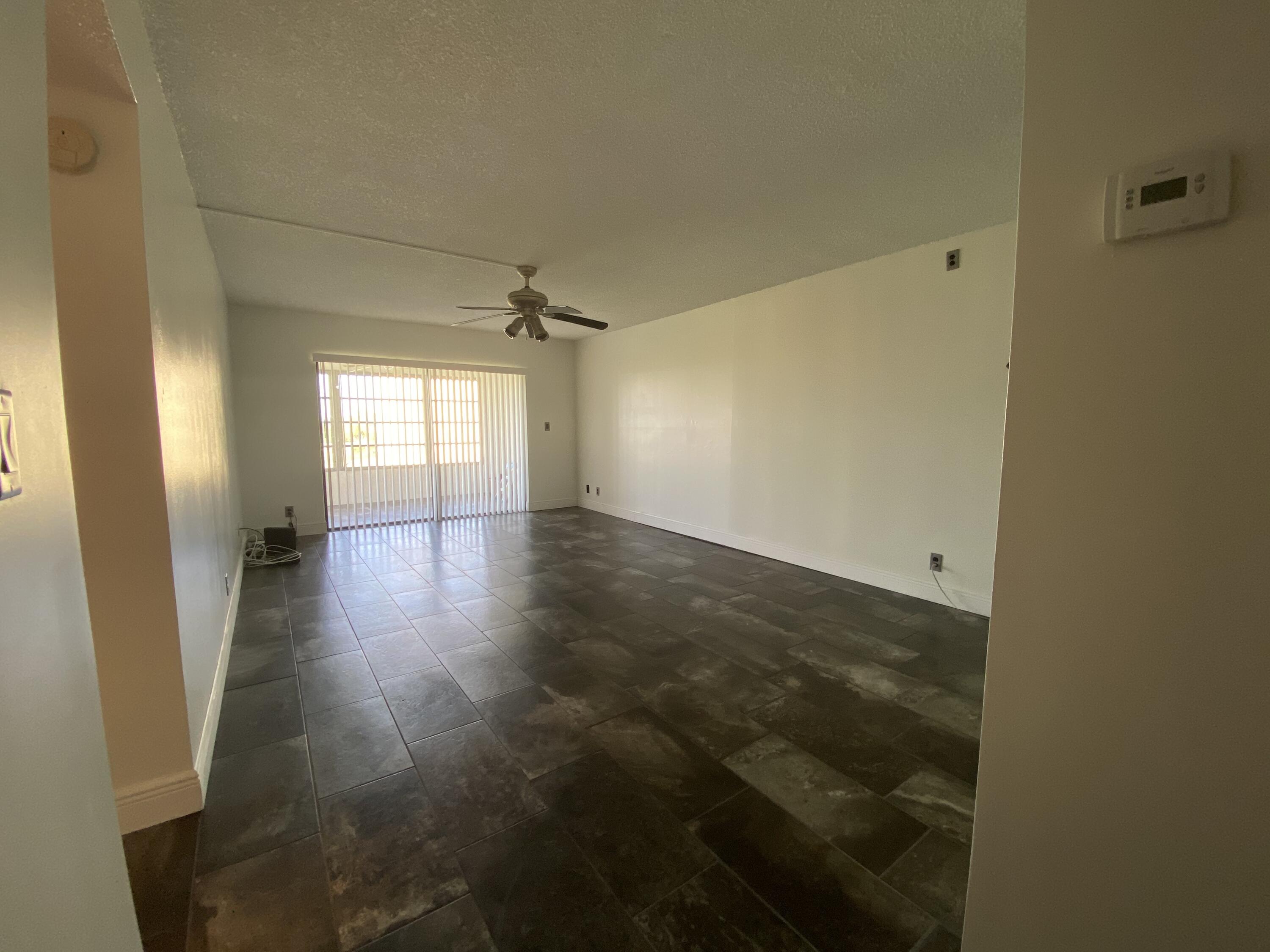 9355 Southwest 8th Street, Unit 305 Boca Raton, FL 33428 - Photo 9 of 13 an empty room with wooden floor and windows