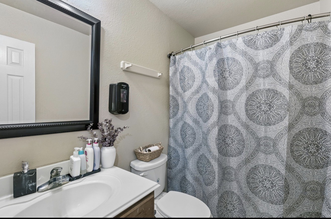 7118 Rising Brook Drive Cypress, TX 77433 - Photo 19 of 21 a bathroom with a toilet sink and mirror