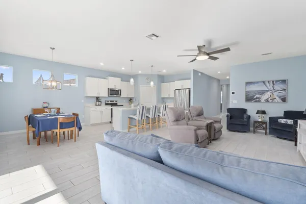 a living room with furniture and a view of kitchen